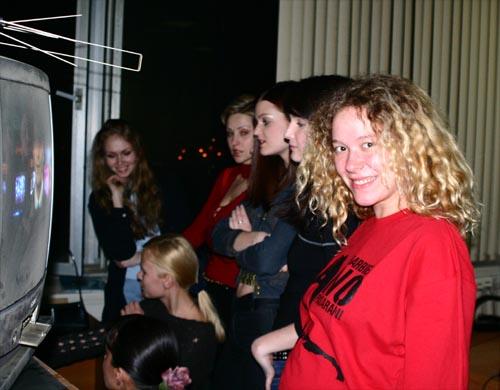 Катя позирует на фоне финалисток русского этапа конкурса "Мисс Вселенная-2004". Надпись на майке - знаменитое "Barbie No Pasaran!" Кит находится внутри Кати, но тоже улыбается.